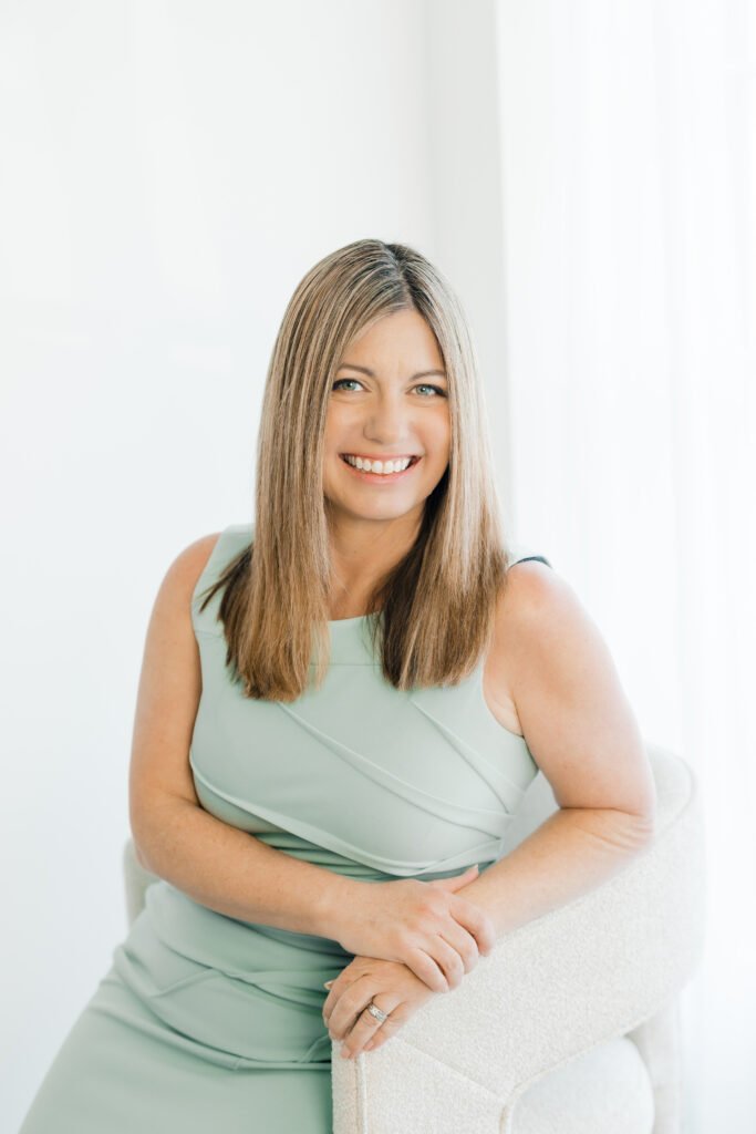 Christy Fisher, Melbourne FL family law attorney and mediator, seated and smiling in a professional portrait.