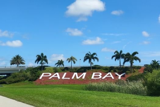 Palm Bay, FL sign surrounded by palm trees